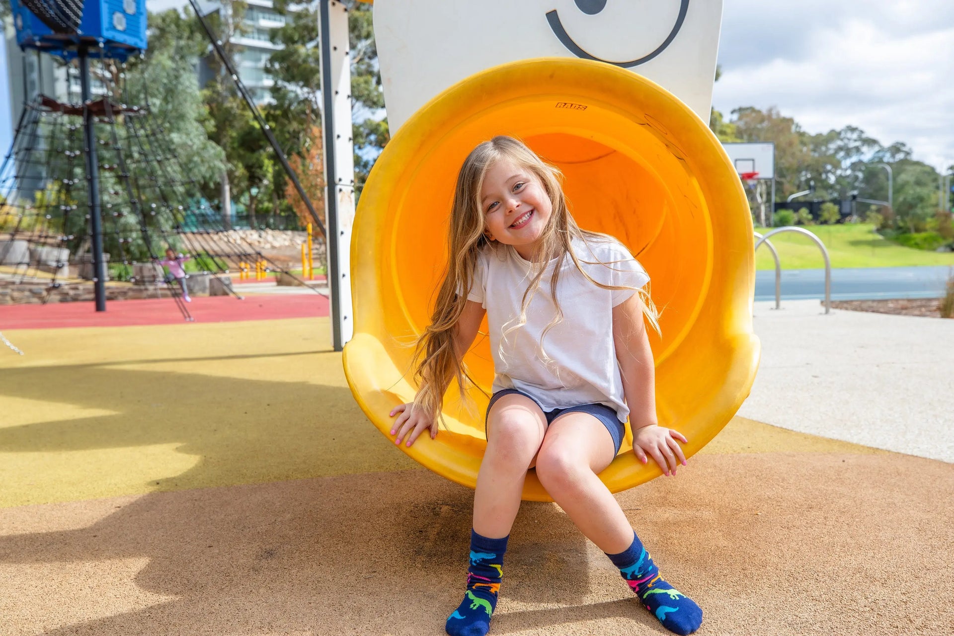 Young girl wearing bright and colourful dinosaur print socks