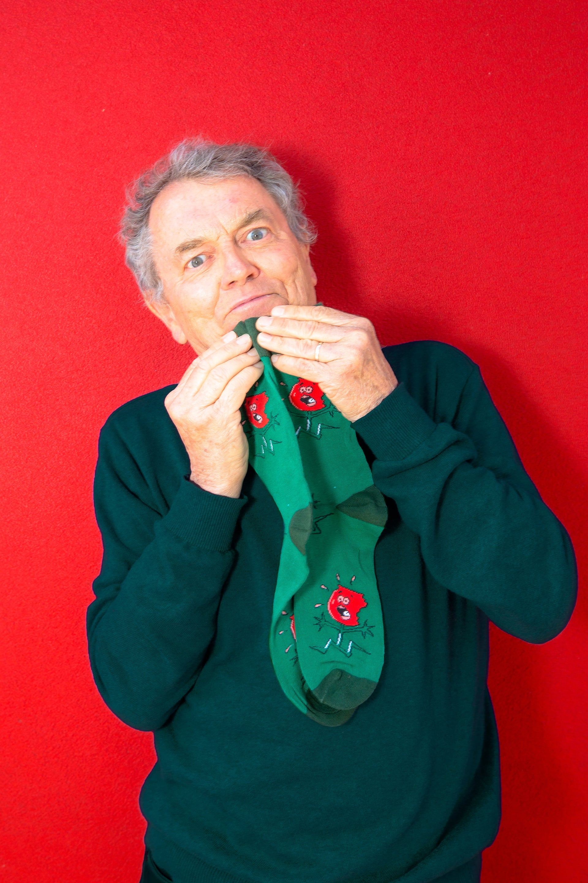 Photo of Peter Combe holding toffee apple socks on chin