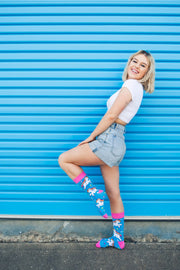 Young Women wearing bright colour unicorn socks against blue background