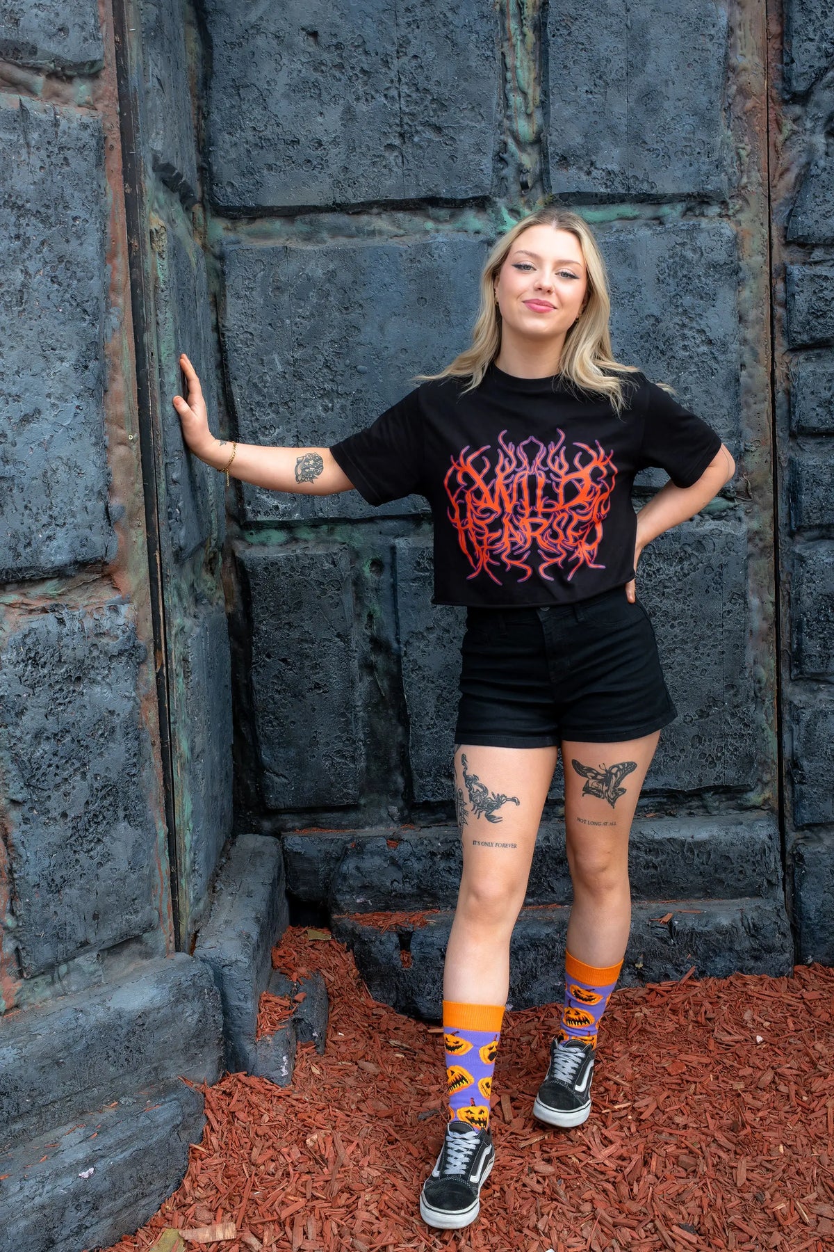Adult wearing pumpkin socks featuring grinning jack-o'-lanterns